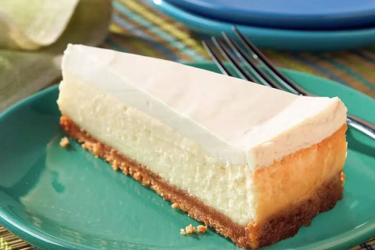 Creamy cheesecake slice on green plate at Crab House, a Cajun Seafood Restaurant in Modesto